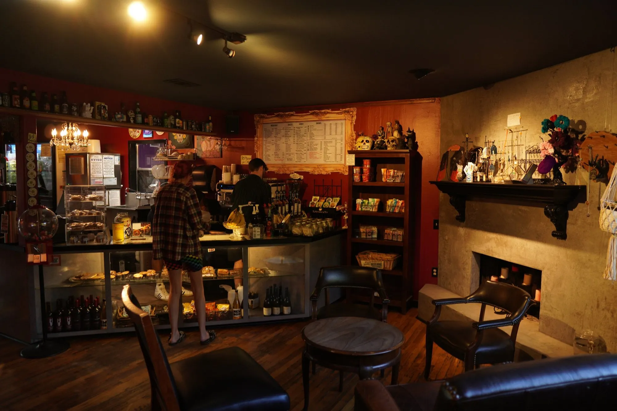 The coffee bar and pastry case beside the fireplace, chandeliers overhead