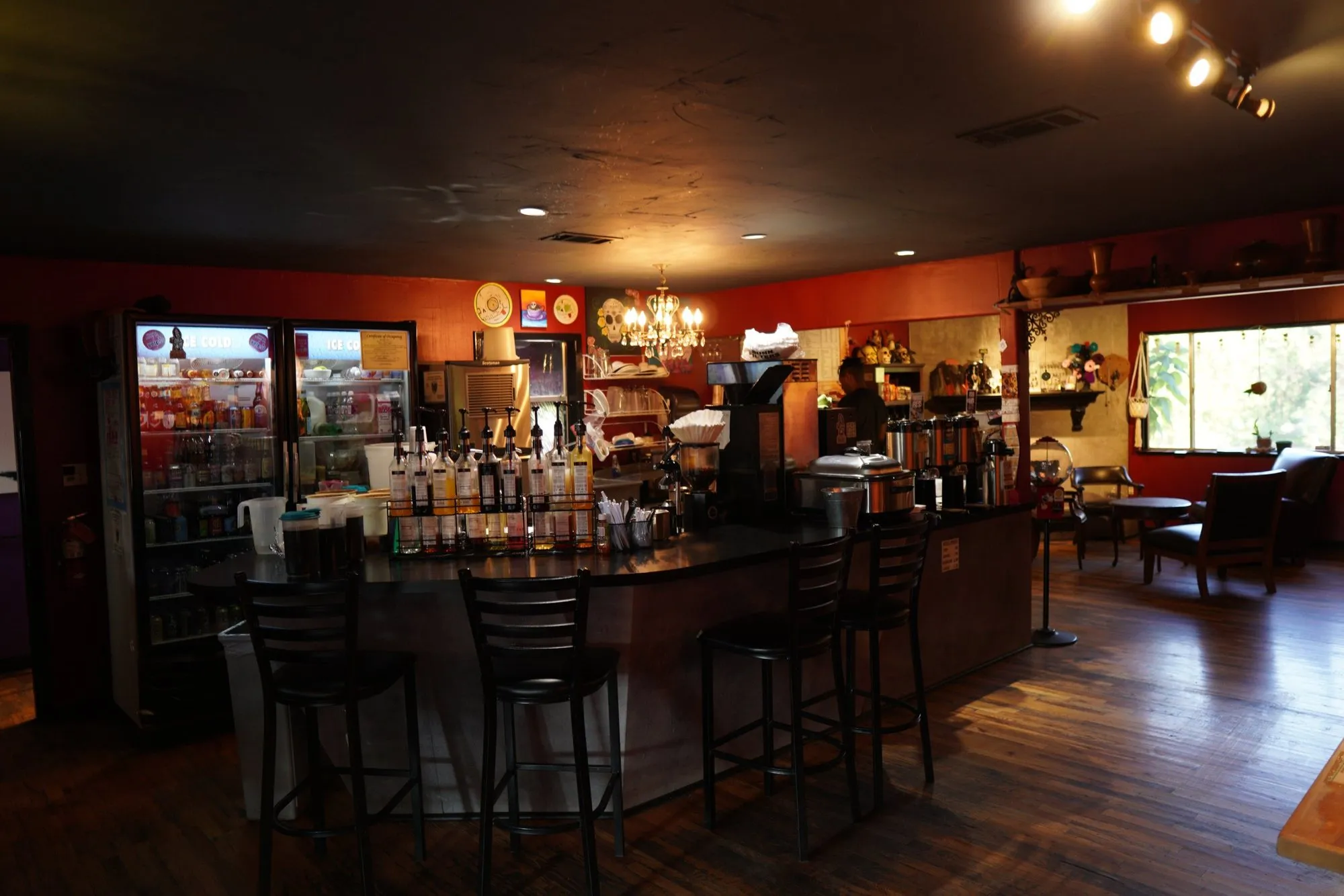 The bar with stools along the windows and shelves of bottles