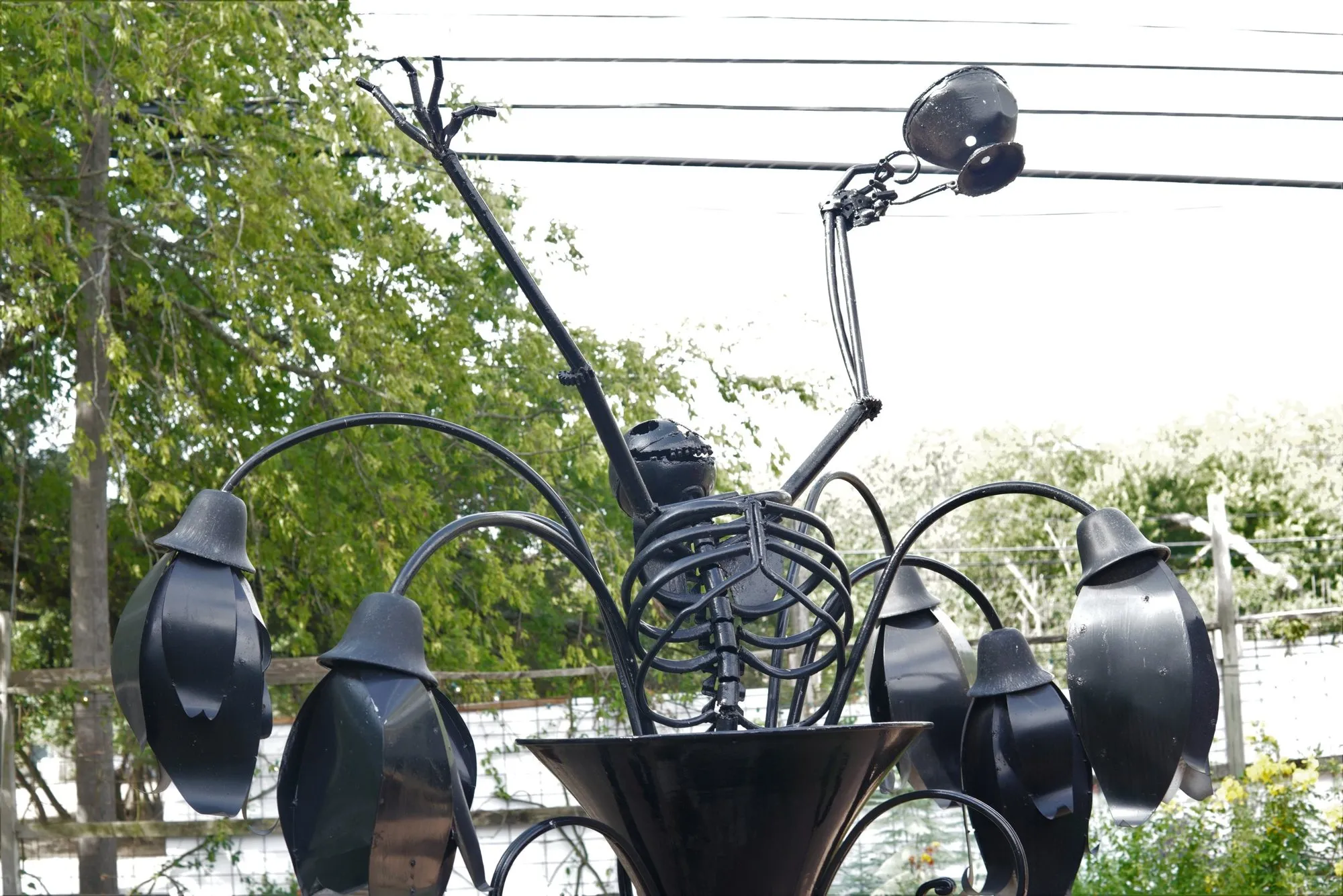 Close-up of the skeleton sculpture against the trees